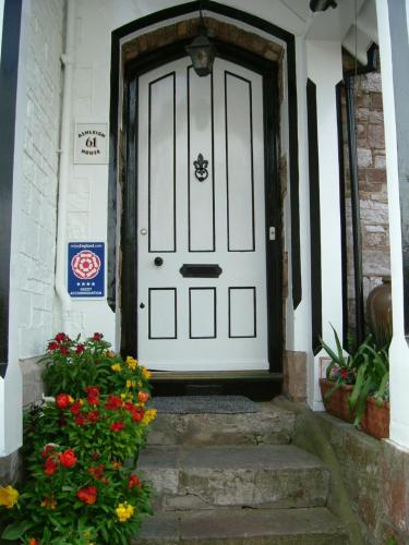 a white door on a house with a bunch of flowers at Ashleigh House in Torquay