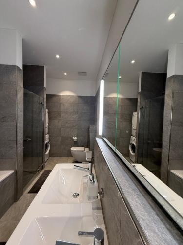 a bathroom with a tub and a sink and a mirror at Bergträume Gauen - CharmingStay in Flumserberg