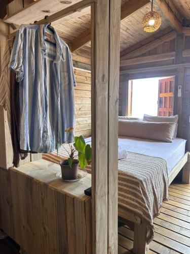 Un dormitorio con una cama en una cabaña de madera. en Casa Muriã, en Caraíva