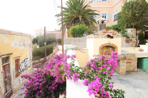 a bunch of purple flowers on a wall at Efi Cozy Loft with Courtyard in Central Ermoupoli in Ermoupoli