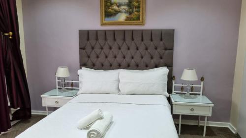 a bedroom with a bed with two nightstands and two tables at Villa D este in Kimberley