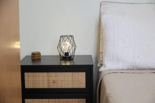 a nightstand with a lamp on it next to a bed at Efi Cozy Loft with Courtyard in Central Ermoupoli in Ermoupoli