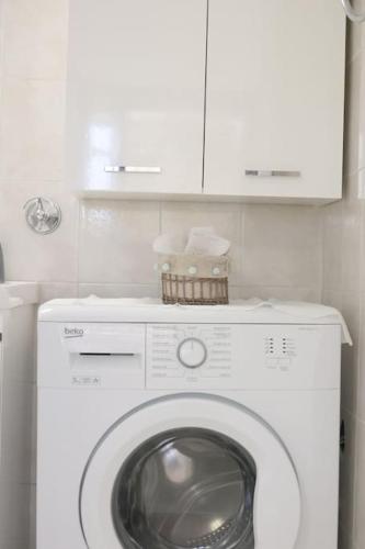 a washer and dryer in a bathroom with a cabinet at Efi Cozy Loft with Courtyard in Central Ermoupoli in Ermoupoli