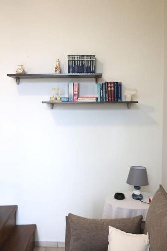 a living room with a couch and shelves on the wall at Efi Cozy Loft with Courtyard in Central Ermoupoli in Ermoupoli