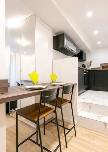 - une cuisine avec une table et deux chaises dans l'établissement General Suite - Strasbourg Hyper Centre, à Strasbourg