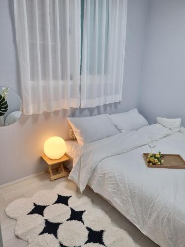 a bedroom with a bed with a table and a rug at 정스테이 서울 잠실 롯데월드 kspodome 아산병원 길동 코엑스 성수명동강남동대문 in Seoul