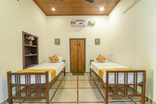 a room with two beds in a room at Thomaskuttys Farmhouse Homestay in Rānī