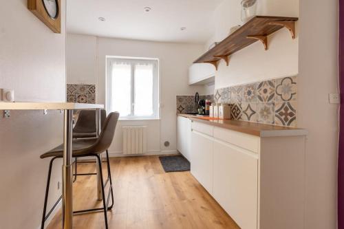 a kitchen with white cabinets and a table and chairs at Appartement centre ville Calais Ines in Calais