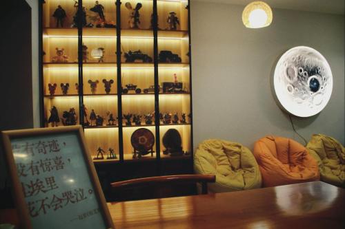 a room with a table and some figurines on a shelf at Yunbo Youth Hostel Ürümqi in Ürümqi