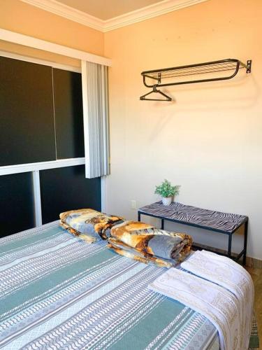 a bedroom with a bed with pillows and a window at Casa Sauê in Aracruz