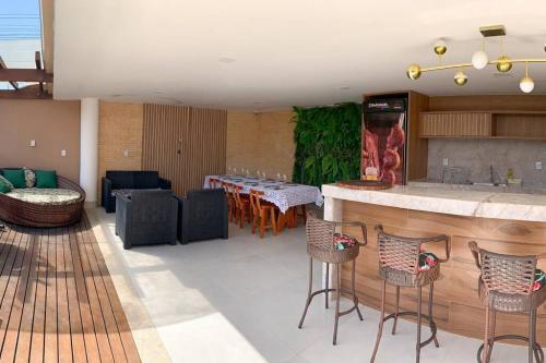 a living room with a bar and a table with chairs at Casa Sauê in Aracruz