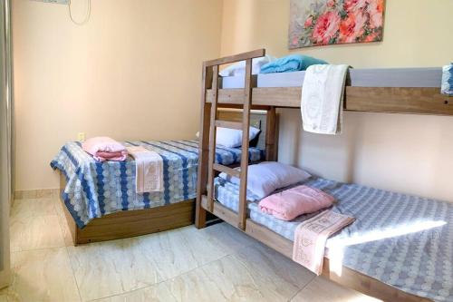 two bunk beds in a room with twounks at Casa Sauê in Aracruz