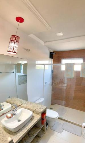 a bathroom with a sink and a toilet and a shower at Casa Sauê in Aracruz