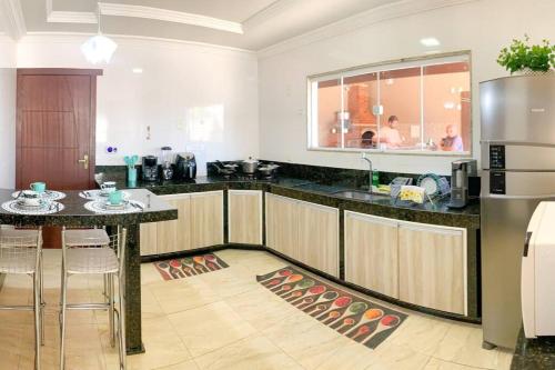 a kitchen with a table and a refrigerator at Casa Sauê in Aracruz