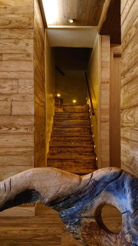 a room with stairs and a large log on the floor at Casa Antón O Cebreiro in O Cebreiro