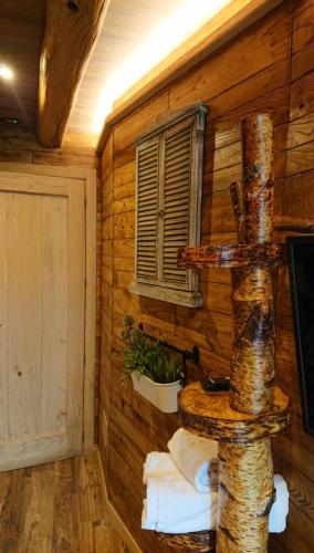 a room with a log wall with a window at Casa Antón O Cebreiro in O Cebreiro