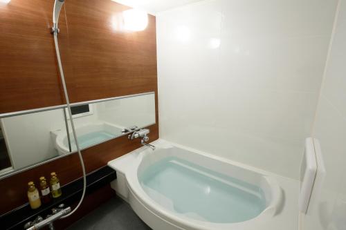a bathroom with a bath tub and a shower at Hotel The Lotus Bali (Adult Only) in Kawasaki