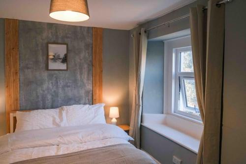 a bedroom with a bed and a window at Hycemoor Escape-Private Hot tub in Corney