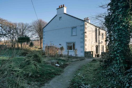 a white house with a dirt road in front of it at Hycemoor Escape-Private Hot tub in Corney