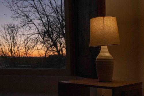 a lamp sitting on a table next to a window at Hycemoor Escape-Private Hot tub in Corney