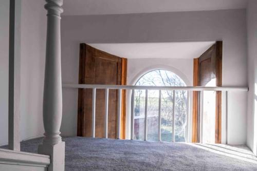 a bedroom with a bed with a large window at Hycemoor Escape-Private Hot tub in Corney