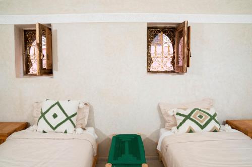 two beds in a room with stained glass windows at Riad Eden Dorient in Marrakech
