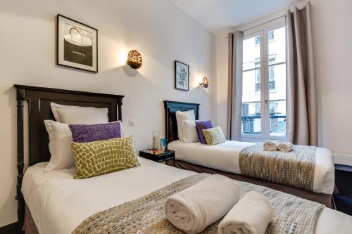 deux lits dans une chambre avec une fenêtre dans l'établissement Sweett - Paix, à Paris