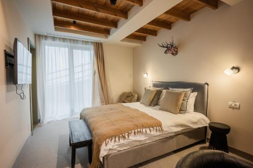 a bedroom with a large bed and a large window at The Pines Bucegi Lodge in Bran