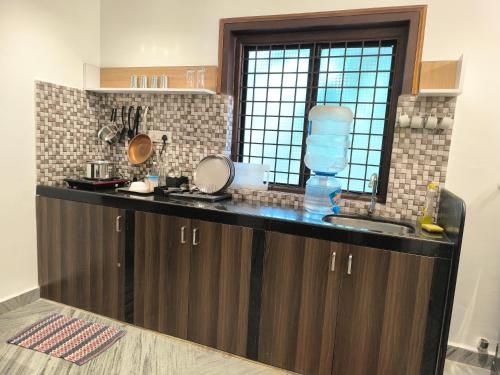 a kitchen with a counter with a sink and a window at Siolim Suites in Siolim