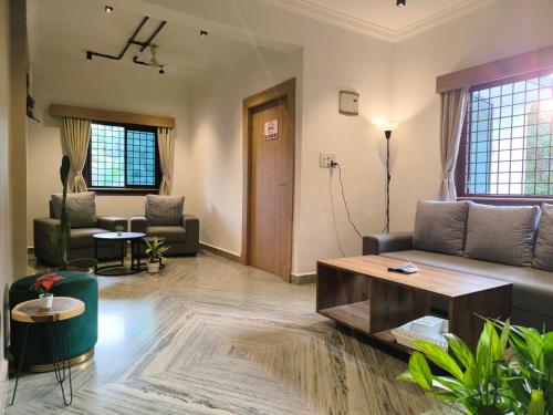 a living room with a couch and a coffee table at Siolim Suites in Siolim