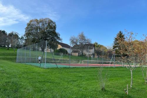 a man standing on a tennis court in a field at Dordogne Le Grand Gîte du Pautys au Cœur du Périgord Vert proche Brantôme in Sorges
