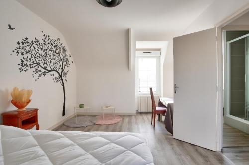 une chambre blanche avec une fresque murale sur les arbres dans l'établissement Dans la campagne d'Erquy, grande maison pour 6, à Erquy