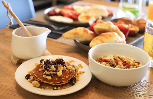 un tavolo con un piatto di pancake e una ciotola di cibo di RIDE Surf Resort & Spa Peniche a Peniche