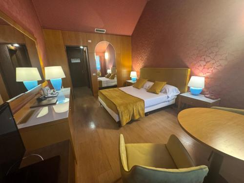 a hotel room with a bed and a table and chairs at Hotel Motel Visconteo in Binasco