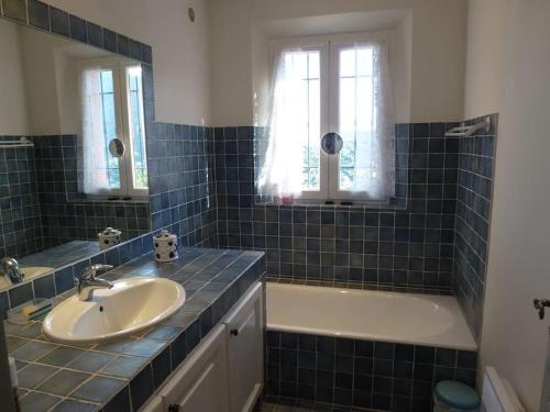 une salle de bain carrelée bleue avec un lavabo et une baignoire dans l'établissement Villa Florentine Cavalaire 7 Pers CLIM WIFI BBQ, à Cavalaire-sur-Mer