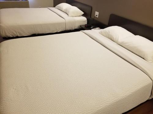 Postel nebo postele na pokoji v ubytování Joys Inn Innisfail, AB