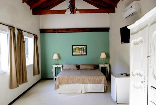 a bedroom with a bed and a green wall at Quebrada Mansa in Nono
