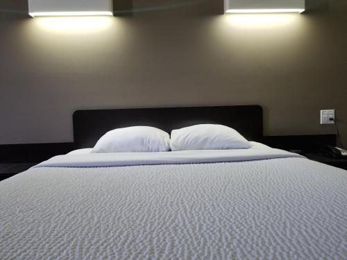 Postel nebo postele na pokoji v ubytování Joys Inn Innisfail, AB
