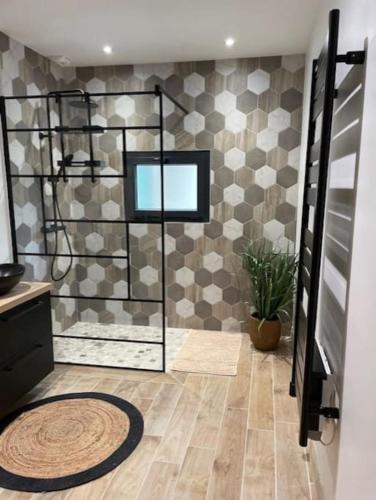 a bathroom with a shower and a tile wall at Maison splendide avec piscine in Ribérac