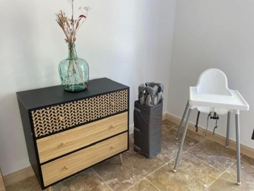 a dresser with a vase on it next to a sink at Maison splendide avec piscine in Ribérac