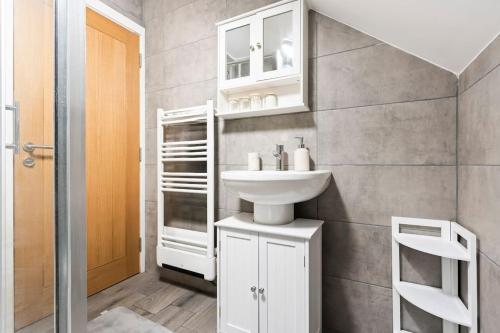 a white bathroom with a sink and a mirror at Modern & cosy 2BR apartment w Balcony & Netflix in Oxford