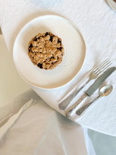 a cookie on a plate next to a fork and knife at CinziaHome Boutique B&B Spiaggia Privata in Lido di Fermo