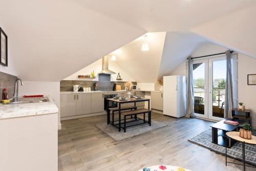 a large kitchen with a table and a refrigerator at Modern & cosy 2BR apartment w Balcony & Netflix in Oxford