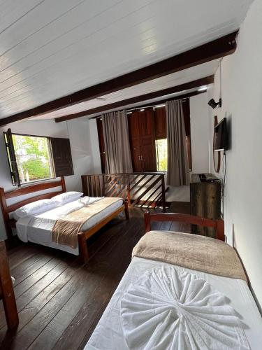 a bedroom with two beds in a room at Pousada Mandala em frente a Praia da Concha in Itacaré