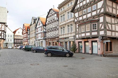 a row of cars parked on a street with buildings at Alsfelder Wein-Suite in Alsfeld
