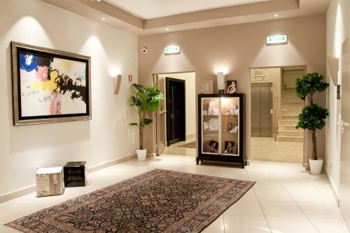 カターニアにあるプラザ ホテル カターニアの広い客室で、壁に敷物と絵が飾られています。
