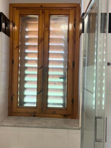 a window with wooden shutters in a bathroom at Sillemi in Letojanni