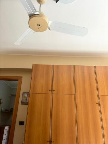 a ceiling fan and a wooden cabinet in a room at Sillemi in Letojanni