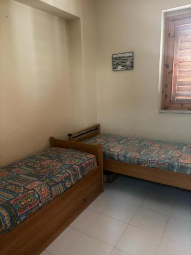 a bedroom with two beds and a window at Sillemi in Letojanni