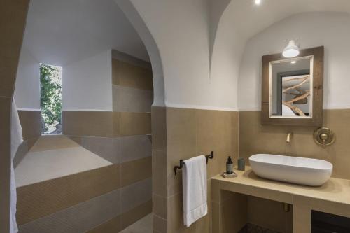 a bathroom with a sink and a mirror at Gallicantu Stazzo Retreat in Luogosanto